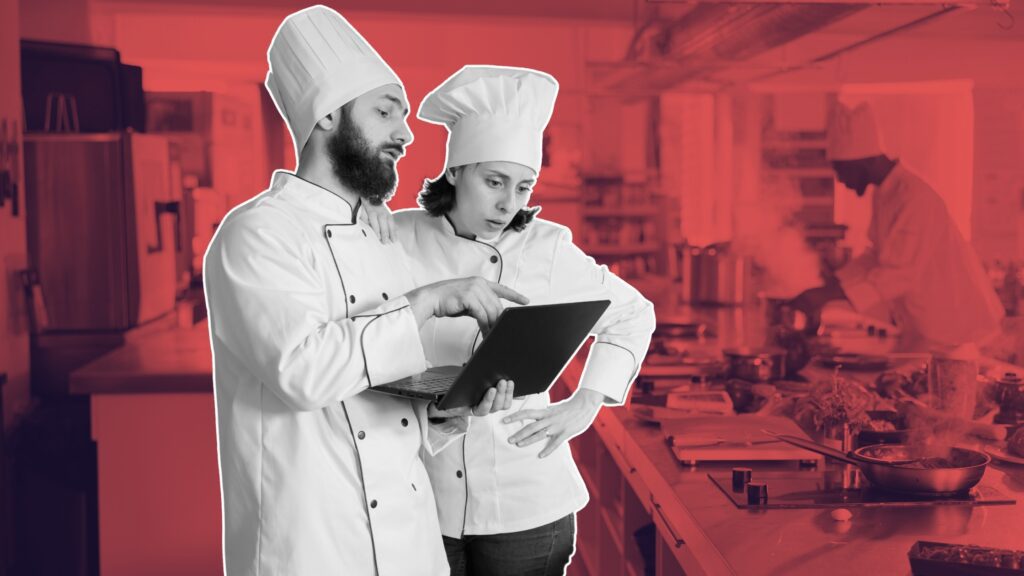 Chefs using hospitality technology in a commercial kitchen