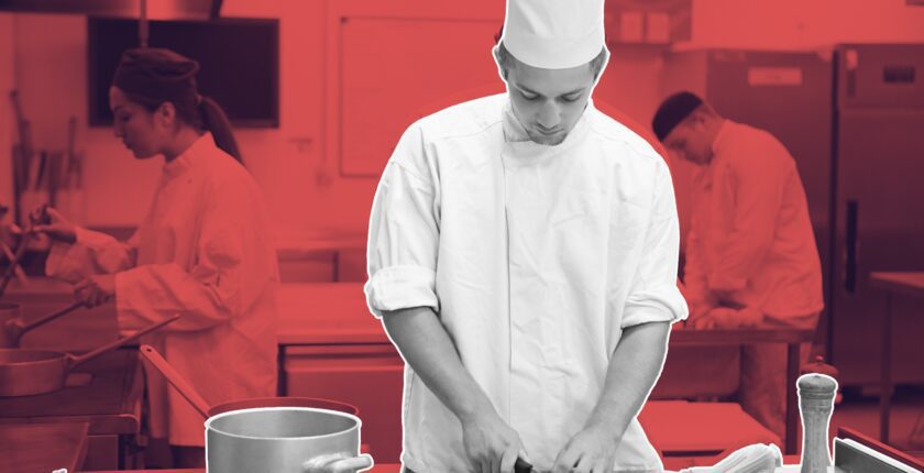 Chef reviewing prep list on kitchen wall clock in background, free time management courses for hospitality